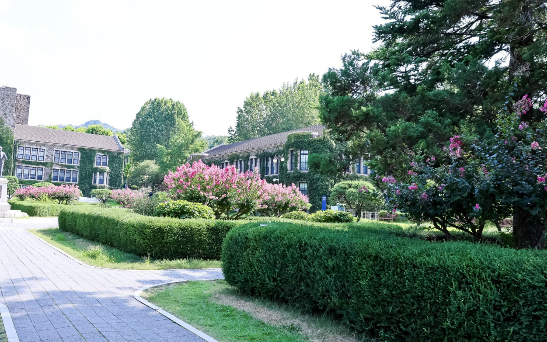 담쟁이 덮인 석조 교사 건물과 정원 산책로