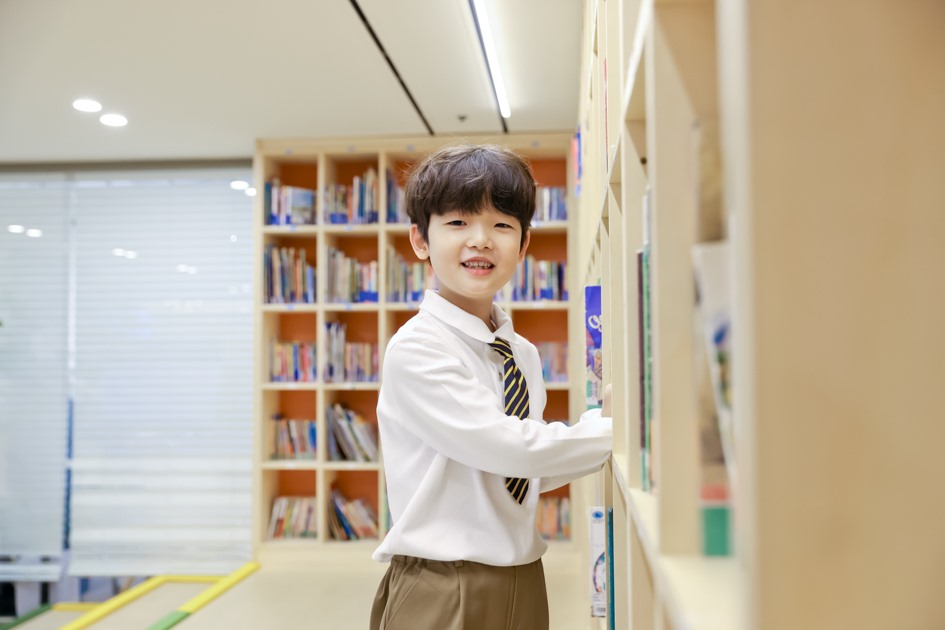 서가 앞에서 카메라를 바라보는 학생 개인 촬영 컷